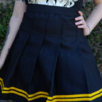 Pollera tablas negra con linea amarilla